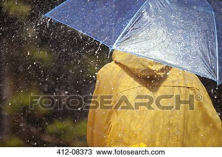 Stock Image - Woman under umbrella in rain. Fotosearch