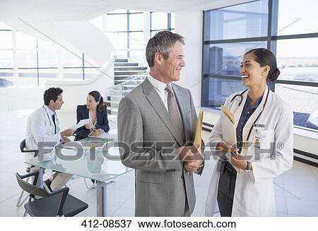 Stock Photo - Businessman and doctor talking in meeting. Fotosearch