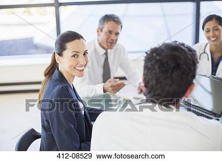 Businesswoman smiling in meeting View Large Photo Image Stock Photo - Businesswoman smiling in meeting. Fotosearch
