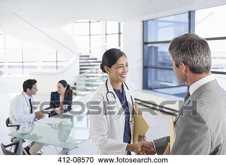 Doctor and businessman handshaking in meeting View Large Photo Image Stock Image - Doctor and businessman handshaking in meeting. Fotosearch