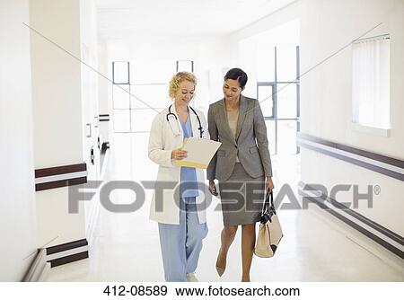 Doctor and businesswoman talking in hospital corridor View Large Photo Image Stock Photo - Doctor and businesswoman talking in hospital corridor. Fotosearch