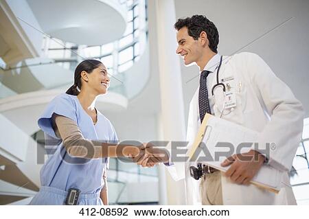 Doctor and nurse handshaking in hospital View Large Photo Image Stock Image - Doctor and nurse handshaking in hospital. Fotosearch