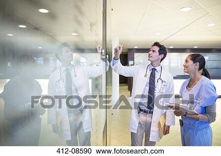 Doctor and nurse talking in hospital corridor View Large Photo Image Stock Image - Doctor and nurse talking in hospital corridor. Fotosearch