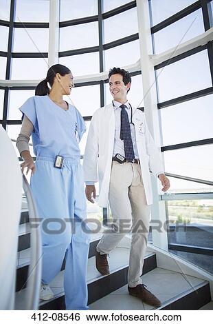 Doctor and nurse talking on staircase View Large Photo Image Stock Photograph - Doctor and nurse talking on staircase. Fotosearch