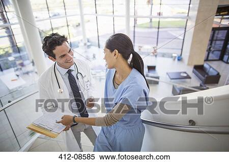 Stock Photography - Doctor and nurse talking on staircase in hospital. Fotosearch
