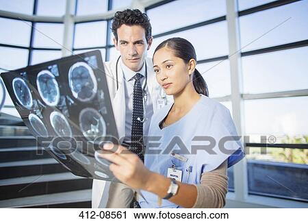 Doctor and nurse viewing head x-rays on hospital staircase View Large Photo Image Stock Image - Doctor and nurse viewing head x-rays on hospital staircase. Fotosearch