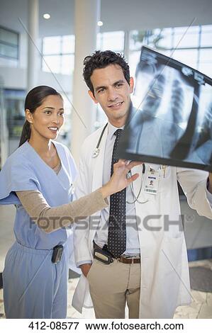 Stock Photo - Doctor and nurse viewing head x-rays. Fotosearch