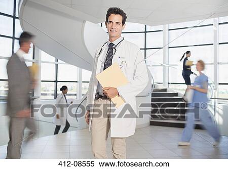 Stock Photography - Doctor carrying folders in hospital. Fotosearch