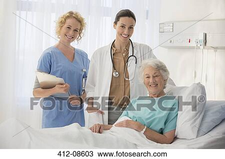 Doctor, nurse and senior patient smiling in hospital room View Large Photo Image Stock Image - Doctor, nurse and senior patient smiling in hospital room. Fotosearch