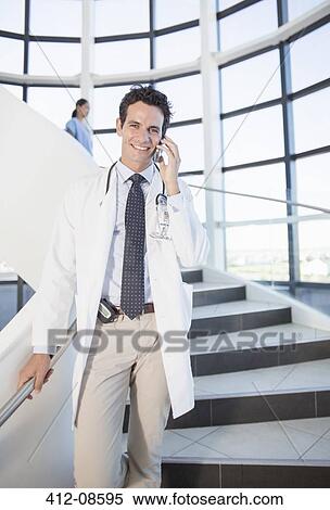 Doctor talking on cell phone in hospital View Large Photo Image Stock Photography - Doctor talking on cell phone in hospital. Fotosearch
