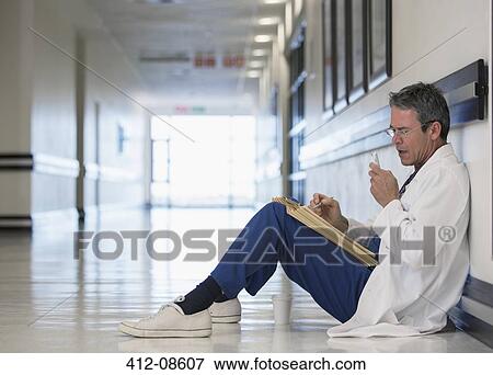 Doctor using dictaphone in hospital corridor View Large Photo Image Stock Photo - Doctor using dictaphone in hospital corridor. Fotosearch