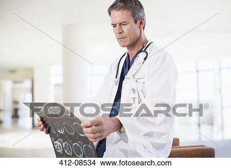 Doctor viewing head x-rays in hospital View Large Photo Image Picture - Doctor viewing head x-rays in hospital. Fotosearch