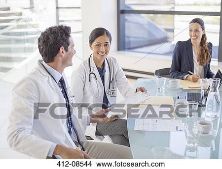 Doctors and businesswoman talking in meeting View Large Photo Image Picture - Doctors and businesswoman talking in meeting. Fotosearch