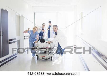 Doctors and nurses rushing patient on stretcher down hospital corridor View Large Photo Image Stock Image - Doctors and nurses rushing patient on stretcher down hospital corridor. Fotosearch
