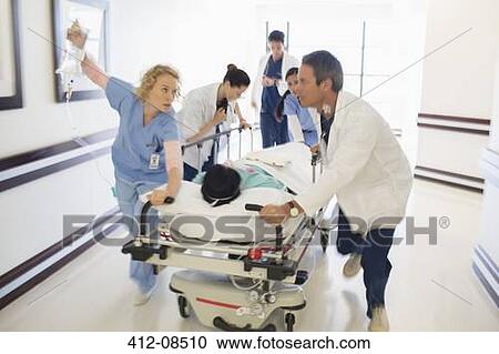 Doctors rushing patient on gurney in hospital corridor View Large Photo Image Stock Image - Doctors rushing patient on gurney in hospital corridor. Fotosearch