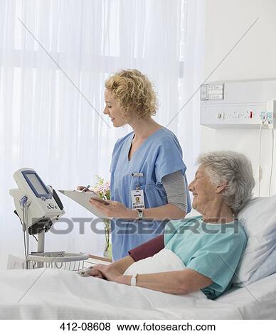 Nurse checking equipment in aging patient's hospital room View Large Photo Image Stock Photo - Nurse checking equipment in aging patient's hospital room. Fotosearch