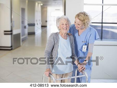 Nurse helping senior patient with walker in hospital corridor View Large Photo Image Stock Image - Nurse helping senior patient with walker in hospital corridor. Fotosearch