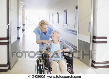 Stock Photography - Nurse with aging patient in wheelchair in hospital corridor. Fotosearch