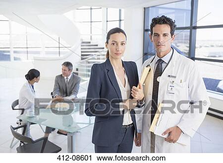 Portrait of confident doctor and businesswoman in meeting View Large Photo Image Stock Image - Portrait of confident doctor and businesswoman in meeting. Fotosearch