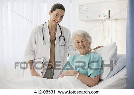 Stock Image - Portrait of doctor and aging patient in hospital room. Fotosearch