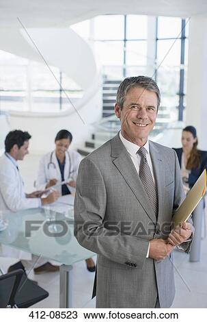 Portrait of smiling businessman in meeting with doctors View Large Photo Image Stock Image - Portrait of smiling businessman in meeting with doctors. Fotosearch