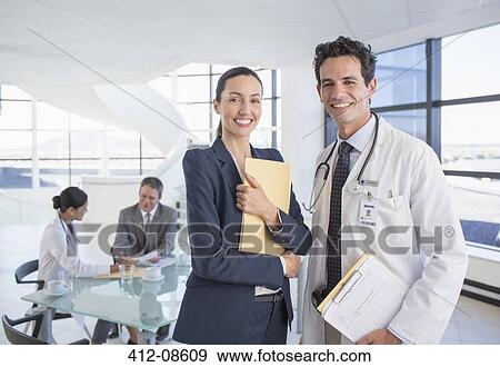 Portrait of smiling businesswoman and doctor in meeting View Large Photo Image Stock Photo - Portrait of smiling businesswoman and doctor in meeting. Fotosearch