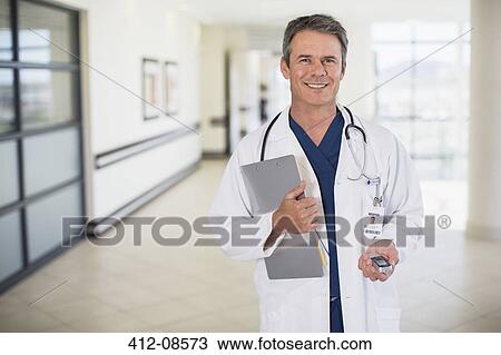 Stock Image - Portrait of smiling doctor in hospital corridor. Fotosearch