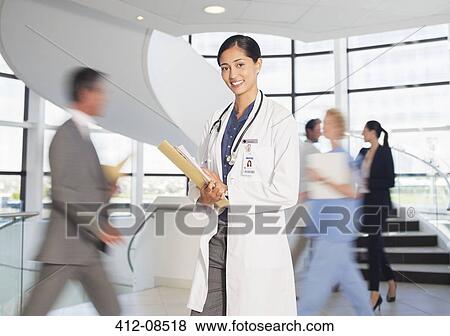 Portrait of smiling doctor in hospital atrium View Large Photo Image Stock Photo - Portrait of smiling doctor in hospital atrium. Fotosearch