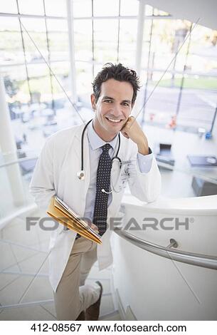 Portrait of smiling doctor on stairs in hospital View Large Photo Image Stock Photo - Portrait of smiling doctor on stairs in hospital. Fotosearch