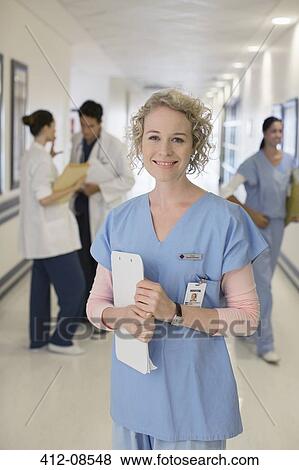 Portrait of smiling nurse in hospital corridor View Large Photo Image Stock Photo - Portrait of smiling nurse in hospital corridor. Fotosearch