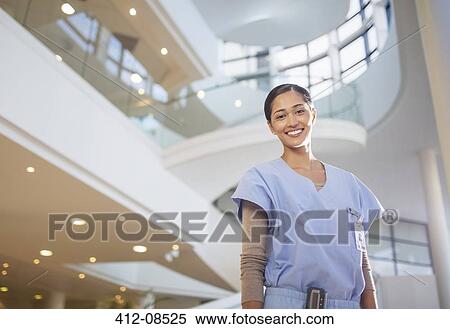 Stock Photography - Portrait of smiling nurse in hospital atrium. Fotosearch