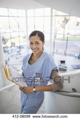Stock Photo - Portrait of smiling nurse on hospital staircase. Fotosearch