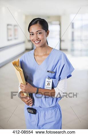 Portrait of smiling nurse with folders in hospital corridor View Large Photo Image Picture - Portrait of smiling nurse with folders in hospital corridor. Fotosearch