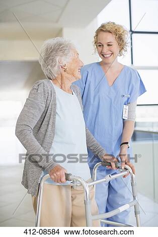 Senior patient with walker smiling at nurse in hospital corridor View Large Photo Image Picture - Senior patient with walker smiling at nurse in hospital corridor. Fotosearch