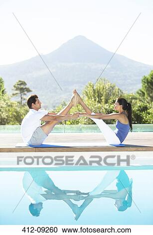Couple practicing yoga poolside View Large Photo Image Stock Image - Couple practicing yoga poolside. Fotosearch