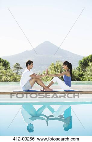 Couple practicing yoga poolside View Large Photo Image Stock Photograph - Couple practicing yoga poolside. Fotosearch