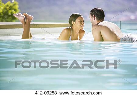 Couple relaxing in swimming pool View Large Photo Image Stock Photo - Couple relaxing in swimming pool. Fotosearch
