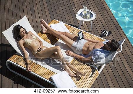 Stock Photo - Couple relaxing poolside. Fotosearch