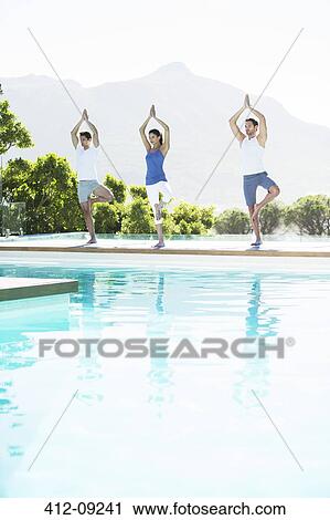 Men and woman practicing yoga at poolside View Large Photo Image Stock Image - Men and woman practicing yoga at poolside. Fotosearch