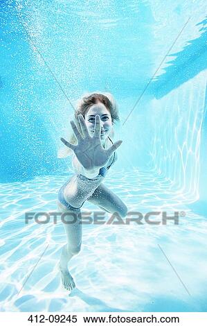 Stock Photography - Portrait of smiling woman underwater in swimming pool. Fotosearch