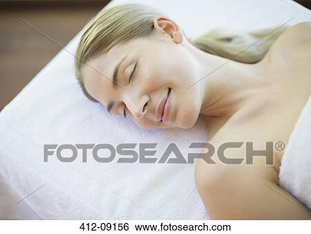 Serene woman laying on massage table View Large Photo Image Stock Photograph - Serene woman laying on massage table. Fotosearch