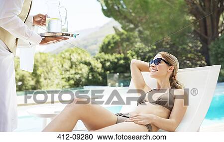 Waiter serving woman at poolside View Large Photo Image Stock Image - Waiter serving woman at poolside. Fotosearch
