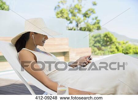 Stock Photo - Woman listening to mp3 player outdoors. Fotosearch