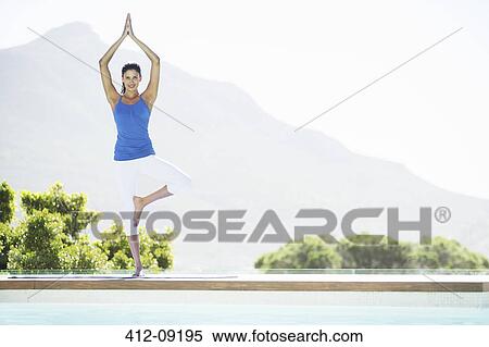 Woman practicing yoga at poolside View Large Photo Image Stock Photography - Woman practicing yoga at poolside. Fotosearch