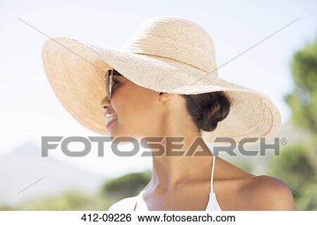 Stock Photograph - Woman wearing sun hat outdoors. Fotosearch