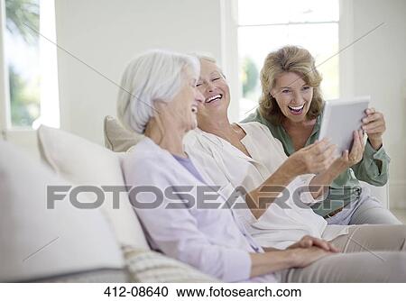 Older women using digital tablet on sofa View Large Photo Image Stock Image - Older women using digital tablet on sofa. Fotosearch