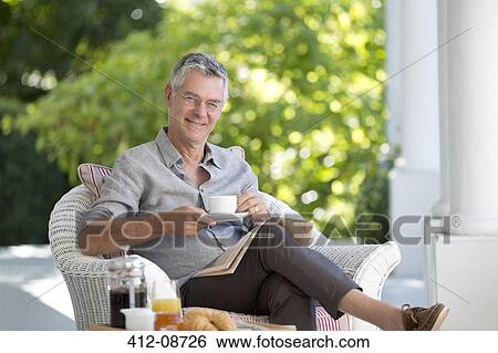 Portrait of smiling senior man drinking coffee on patio View Large Photo Image Stock Photograph - Portrait of smiling senior man drinking coffee on patio. Fotosearch
