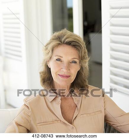 Stock Image - Portrait of smiling senior woman on patio. Fotosearch
