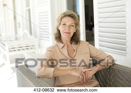 Portrait of smiling senior woman sitting on patio View Large Photo Image Stock Image - Portrait of smiling senior woman sitting on patio. Fotosearch
