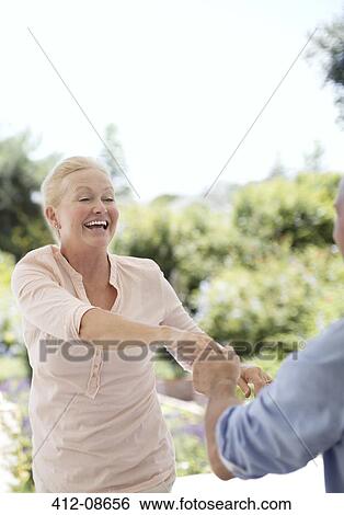 Stock Photograph - Senior couple dancing on patio. Fotosearch